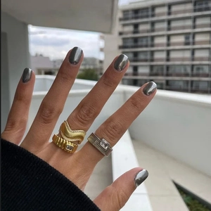 Elegant 18k gold plated wave rings with emerald-cut zircons worn in natural light