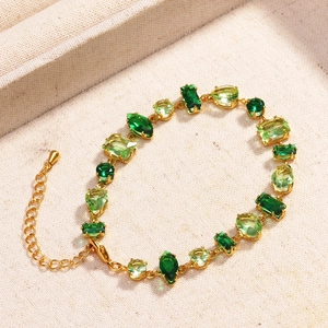 Detailed shot of a gold-plated bracelet with multi-tone green zircon stones and extension chain