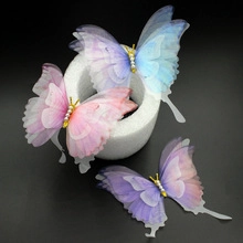 Détail des broches papillon délicates en organza avec corps en perle et ailes en dégradé