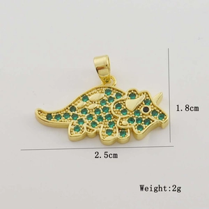Detailed view of triceratops pendant with green and red zircons in 18K gold plating