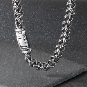 Detailed close-up of thick silver-tone woven dragon bone chain with secure push clasp