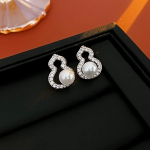 Detail of silver gourd-shaped earrings with micro-inlaid diamonds and white pearls