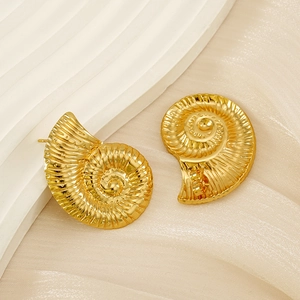 Macro shot of gold spiral conch shell earrings featuring intricate radial relief textures