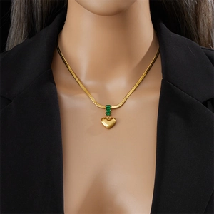 Gold snake bone necklace with heart pendant and emerald green rectangular gemstone