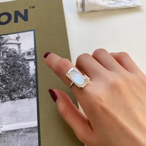 Macro detail of a 925 sterling silver ring featuring a shell oval inlay on finger