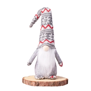 Christmas gnome doll with snowflake knit hat standing on a natural wooden base