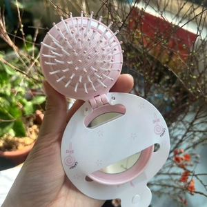Pink candy-themed folding mirror hairbrush with massage bristles and compact round design