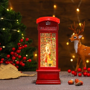 Detail of red Christmas telephone booth with LED light, Santa Claus, and swirling glitter