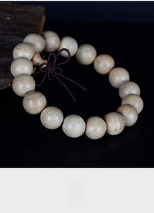 Macro detail of natural camphor wood beads showing rich texture and decorative Chinese knot