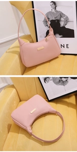Pink lychee texture shoulder bag with golden metal logo and leaf zipper detail on velvet