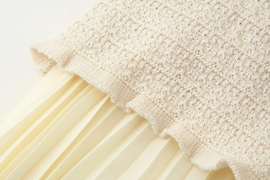 Gros plan détaillé montrant la maille beige épaisse cousue avec du tissu en mousseline plissée