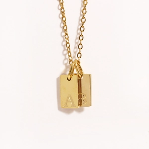 Detailed macro shot of 18k gold plated square alphabet pendants with A and B engravings