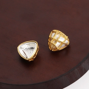 Detailed macro view of gold-plated triangle stud earrings with a woven metal texture