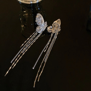 Detailed view of silver butterfly ear cuff with shimmering zircon and long fringe tassels