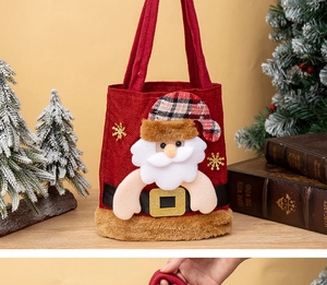 Détail du sac cadeau de Noël en lin rouge avec bordure en peluche et motif Père Noël