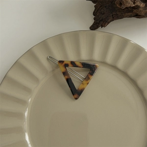 Detailed view of a dark tortoiseshell acetate hair claw clip with triangular design