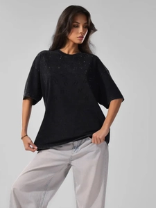 Close-up of vintage wash cotton texture and embossed logo on oversized black t-shirt