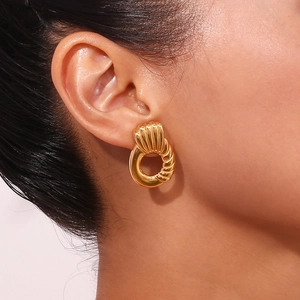 Close-up of 18K gold plated stainless steel hoop earrings with spiral texture on ear