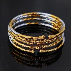 Detailed macro view of four twisted gold and silver plated bangles with bead ends