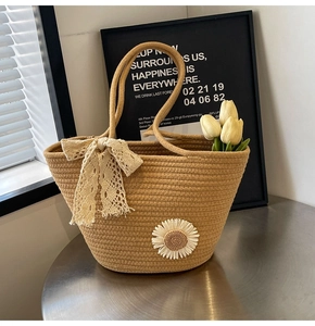Detail of hand-woven tote bag with white daisy applique and delicate cream lace bow