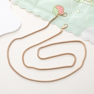 Detailed view of a golden metal snake bone chain strap with lobster clasps on each end