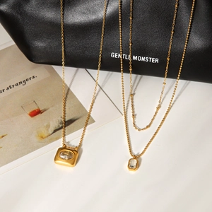 Detailed view of 18K gold plated necklaces with zircon pendants on leather background