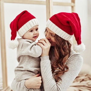Red and white knitted Christmas parent-child hats with white pom poms for winter warmth