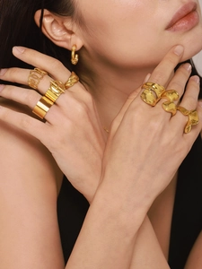 Detail of a model wearing a stack of minimalist 18K gold plated stainless steel rings