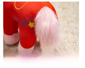Detail of red plush zodiac horse toy featuring a soft pink fluffy tail and delicate embroidery