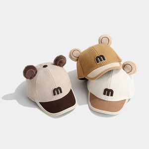 Close-up of three kids winter baseball caps with M letters, bear ears and corduroy brims