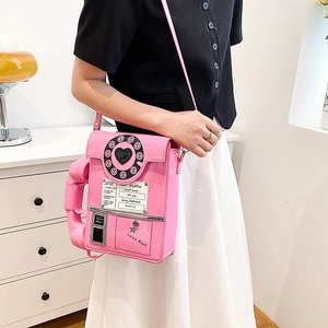 Detail of creative pink telephone shaped crossbody bag with heart dial and retro text