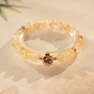 Macro shot of citrine quartz bracelet with golden hollow bead and blue labradorite