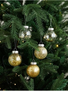 Detailed view of 6cm gold and clear painted Christmas balls hanging on a pine tree