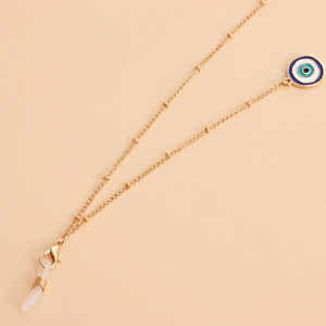 Detail of evil eye pendant on gold glasses chain with beads and silicone loops