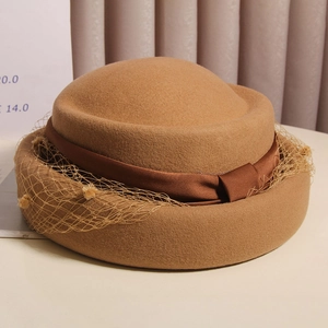 Detail of vintage French wool beret featuring elegant mesh veil and brown satin bow