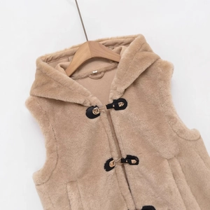 Beige faux fur hooded vest with black leather buckles and metal fasteners