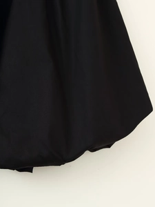 Detail of black pleated lantern hem with smooth fabric texture on vacation dress