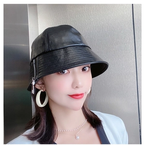 Detail view of a black leather bucket hat with a stylish silver zipper decoration