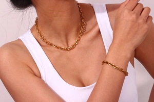 Close-up of 18K gold plated chunky chain necklace and bracelet set on a model