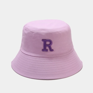 Détail du chapeau bob lilas avec un logo brodé de la lettre R en violet foncé sur le devant