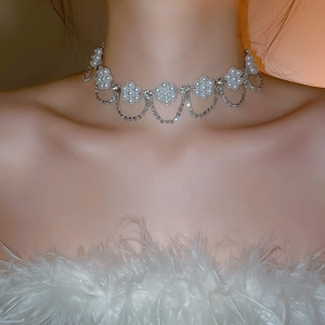 Detail of floral pearl choker with shimmering rhinestone tassels on model neckline