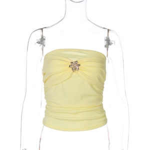 Detalle de top palabra de honor amarillo fruncido con hebilla floral de metal dorado