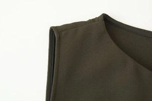 Detailed close-up of dark olive green sleeveless dress showing fine seams and woven texture
