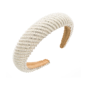 Close-up of wide velvet headband with thick white pearls and sparkling rhinestones