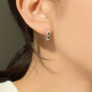Elegant 925 sterling silver hoop earrings with star engraving worn by a model