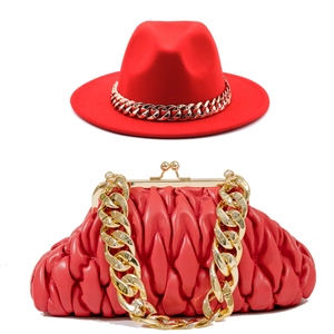 Red fedora hat with gold chain and matching quilted cloud bag set in a modern urban style