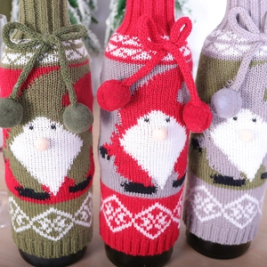 Three-piece knitted Santa wine bottle covers in green, red, and purple with tassels