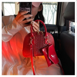 Detail of red crocodile pattern shell bag with small coin purse and long strap