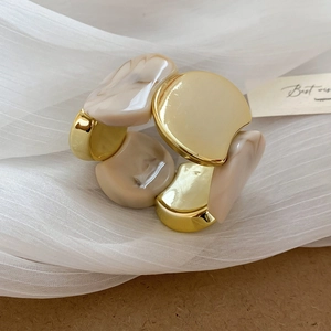 Vue détaillée du bracelet élastique avec métal doré et blocs de résine marbre beige