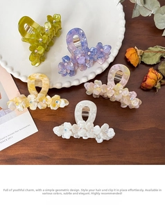 Acetate flower hair claws with rhinestones in multiple colors on a porcelain plate